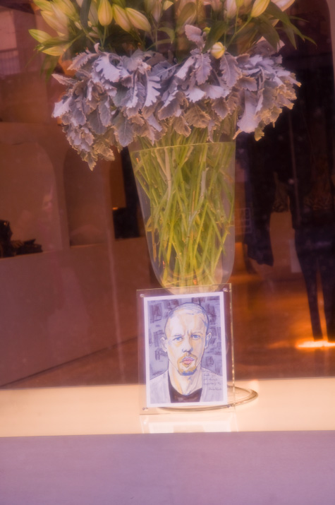 A picture close up picture of Danny Roberts tribute painting of Lee Alexander McQueen in the McQueen Store in New York City with a flow vase