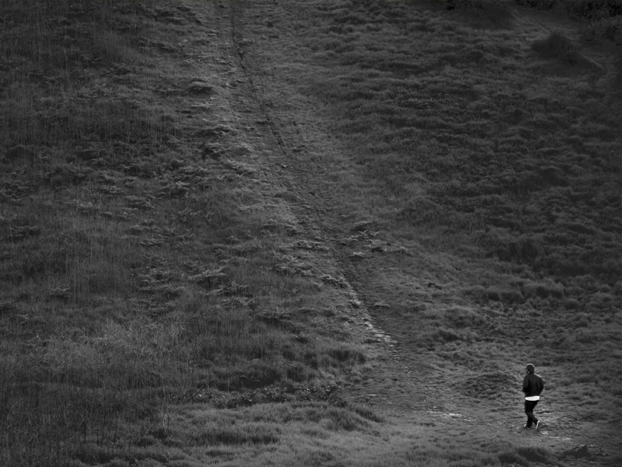 Ryan Baxley walking up a grass hill photo by Roberts