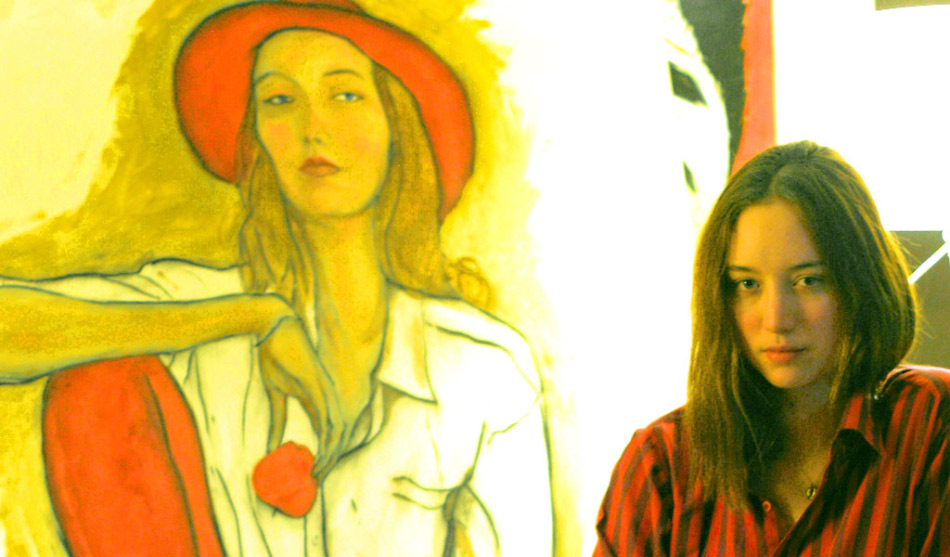 This is a Picture of Model Sophie Ward in front of Danny Roberts painting of her